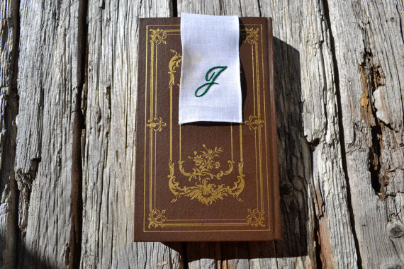 Monogrammed bookmark embroidered with green initial in vintage book