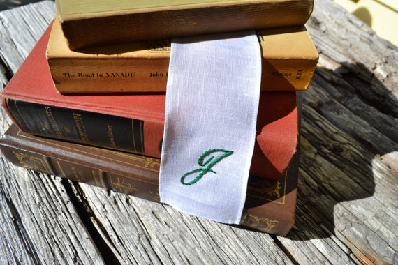 Irish linen bookmark hand stitched with copperplate initial in stack of books