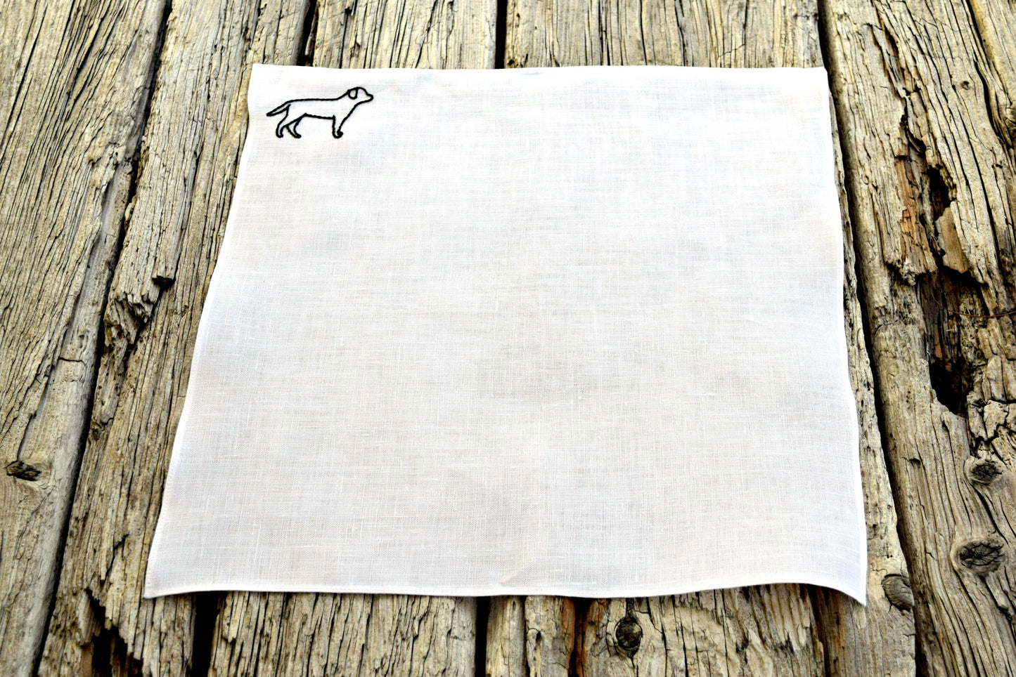 White linen pocket square with black lab outline hand embroidered in upper left hand corner