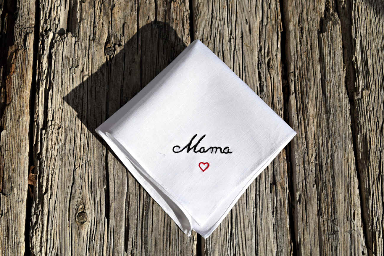White Irish linen handkerchief embroidered with the name 'Mama' in black cursive with a small red heart