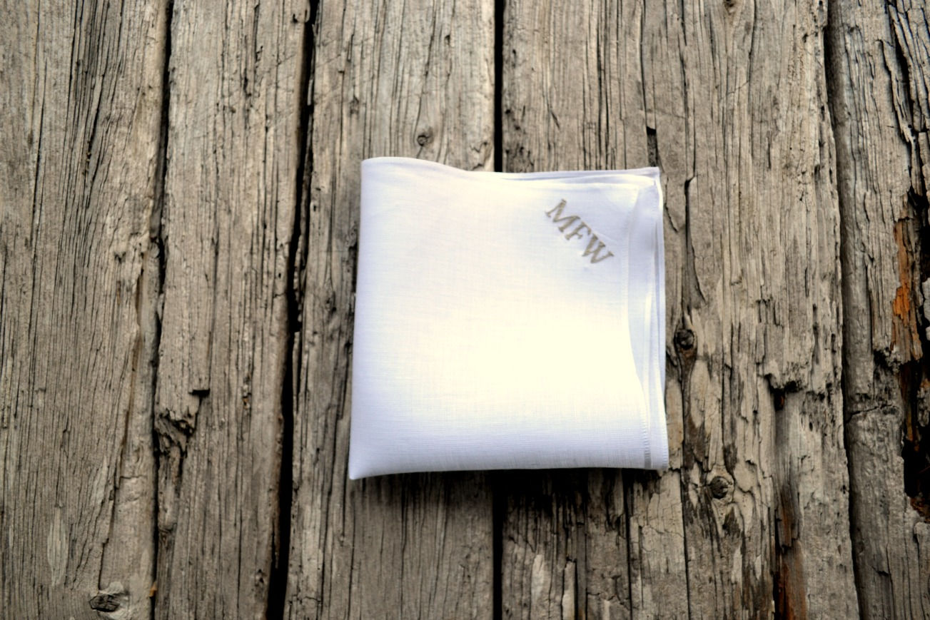 White linen pocket square with initials MFW in small block letters in upper right-hand corner in grey