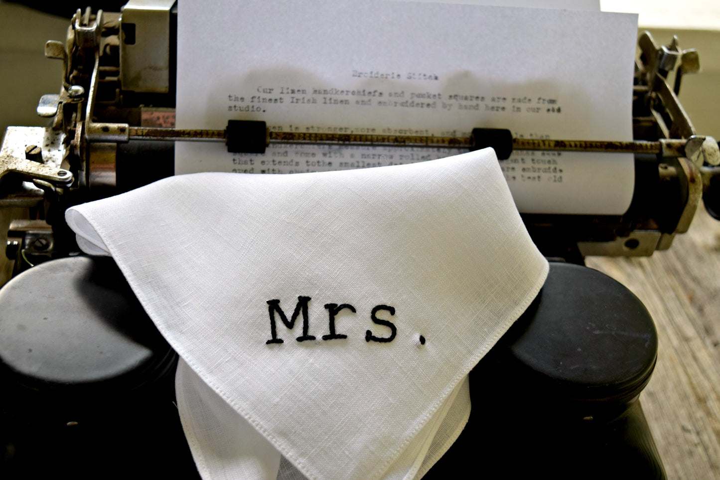 White linen handkerchief embroidered with Mrs. in typewriter script on typewriter