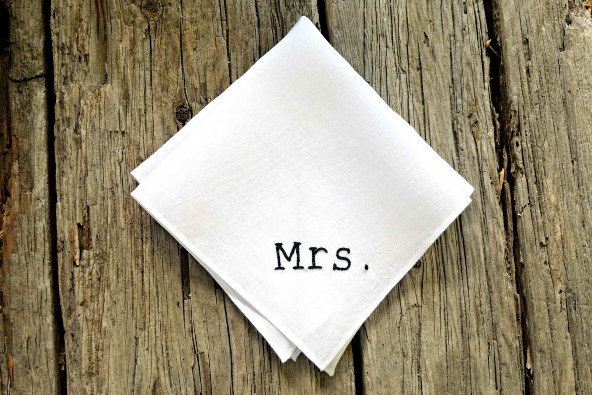 Mrs. new bride handkerchief made of white Irish linen on wood background
