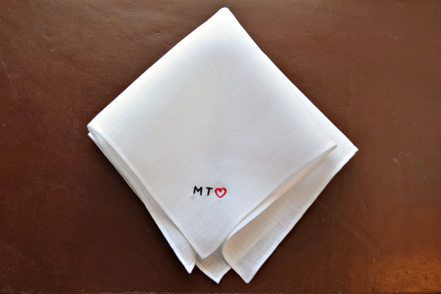 White pocket square hand embroidered with tiny block initials and heart