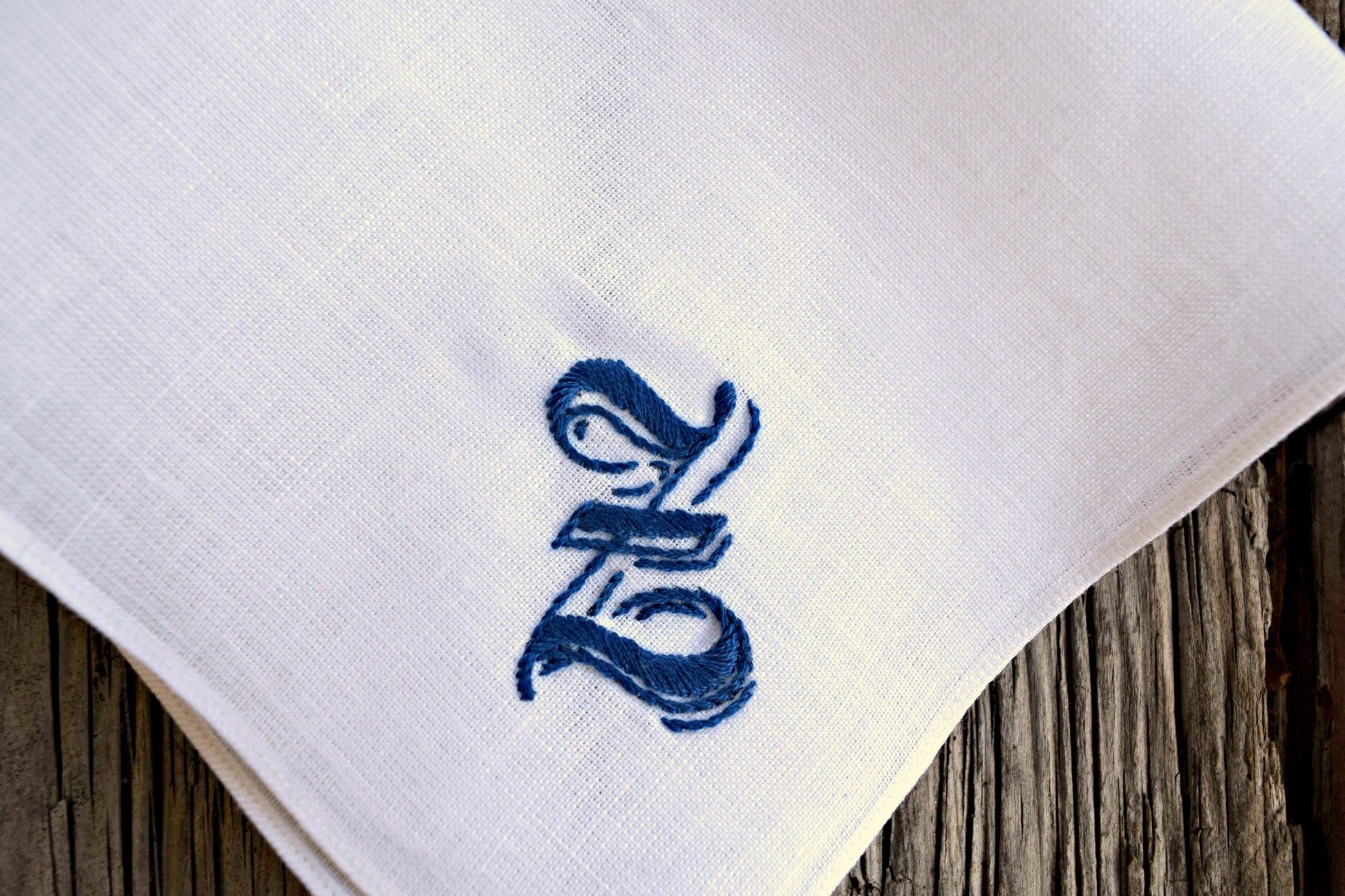 Close up of handkerchief hand embroidered with an large blue letter Z in a gothic script
